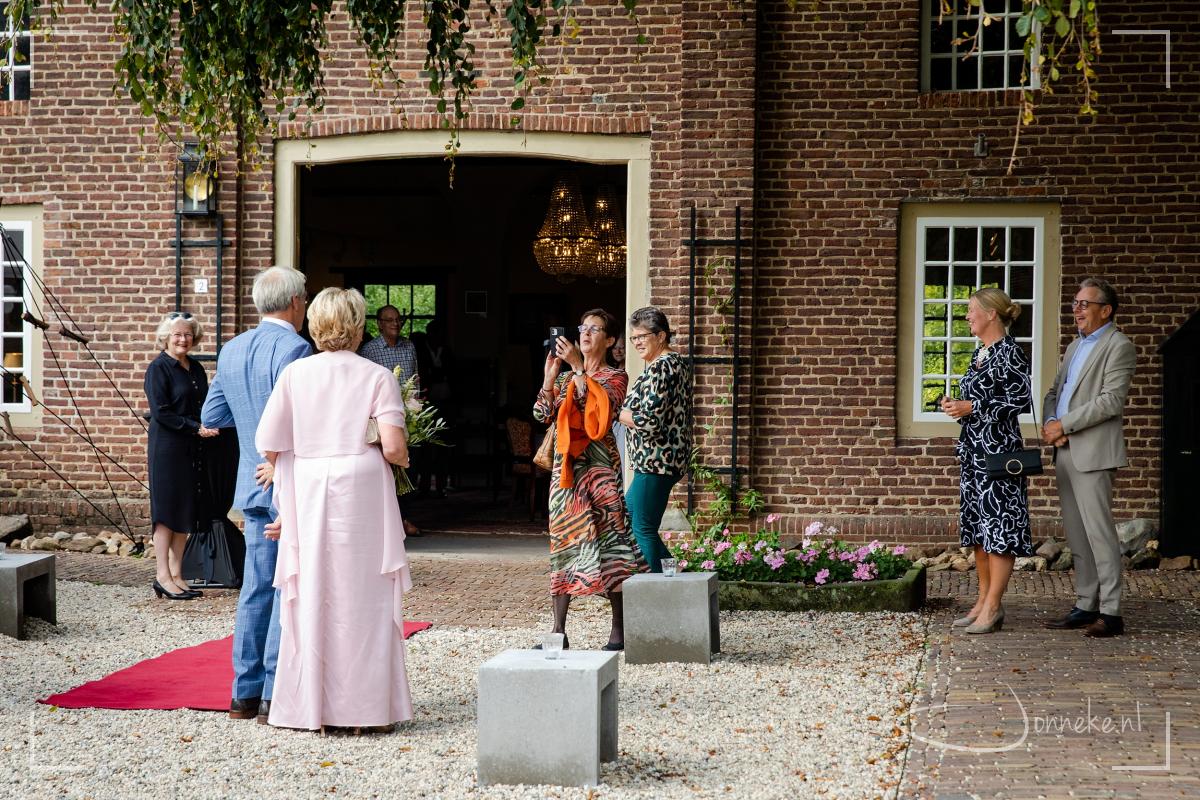 Naaste familie en vrienden staan klaar om het bruidspaar te verwelkomen.
