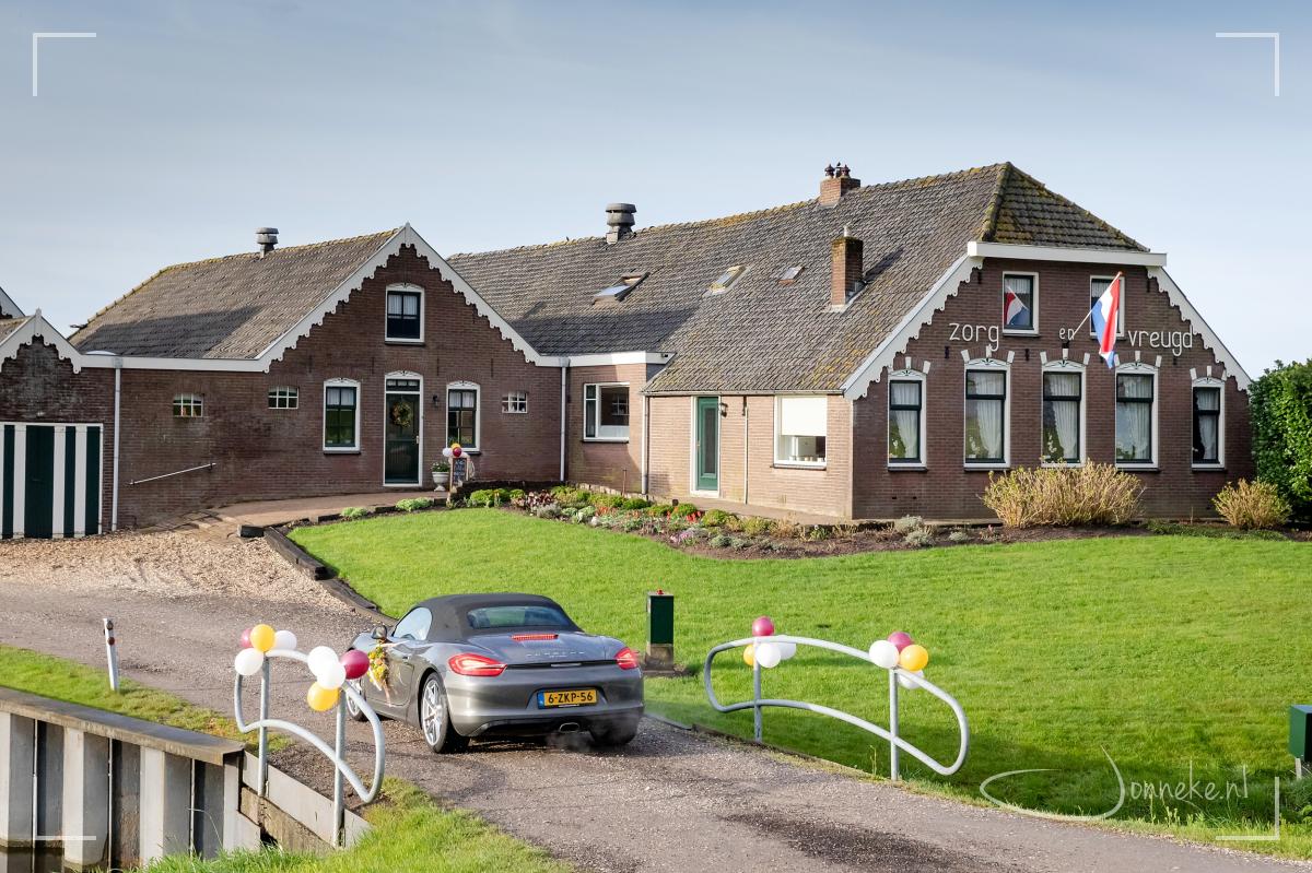 Blauwe lucht boven de boerderij, een pikzwarte lucht aan de andere kant van de dijk.